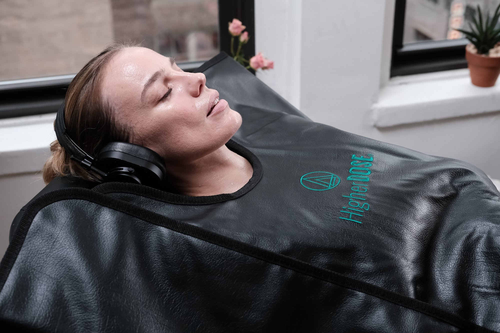woman wearing headphones and enjoying higherdose sauna blanket