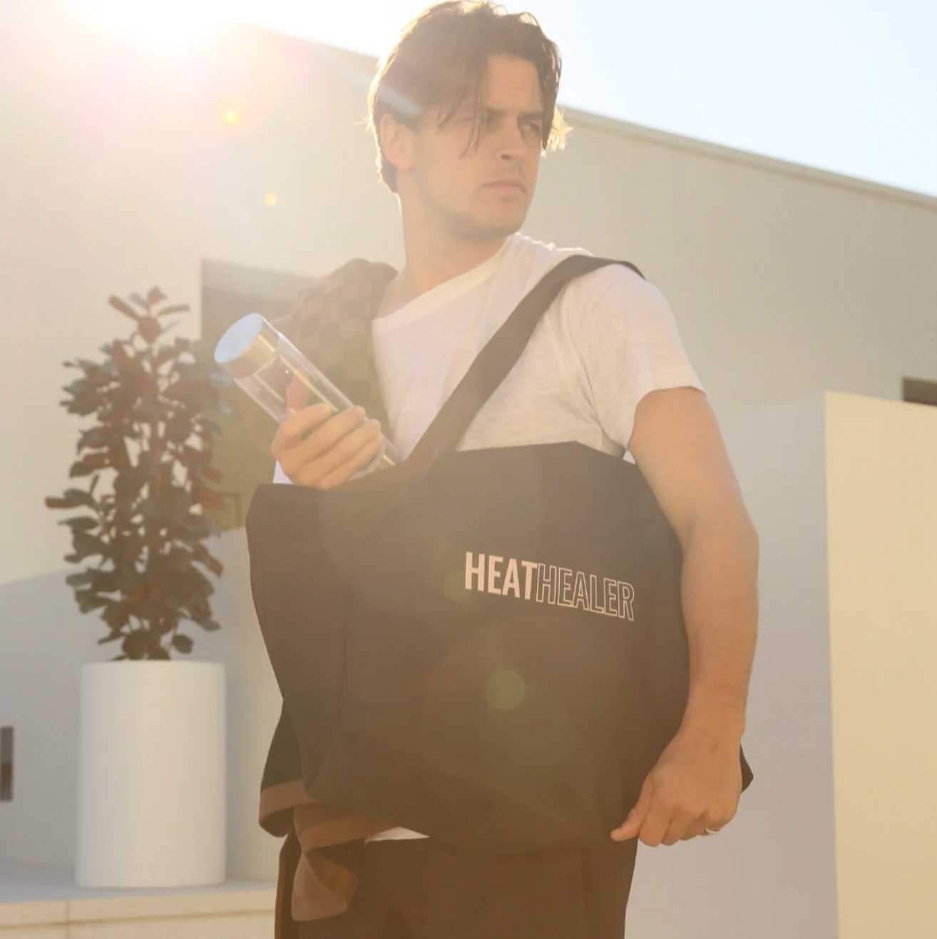 man carrying the heat healer sauna blanket in a bag over his shoulder