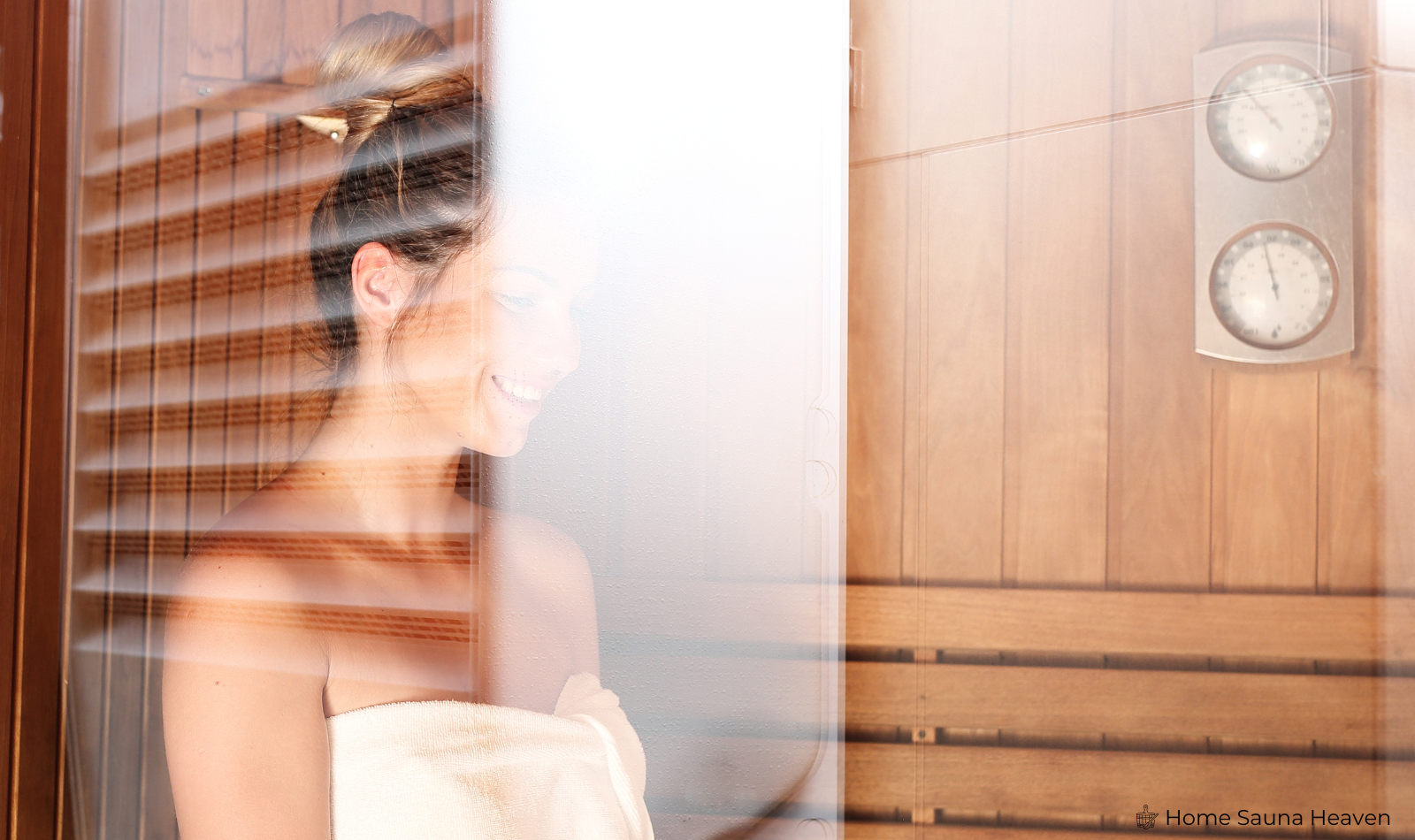woman standing inside a sauna with a glass door and temperature gauges on the wall