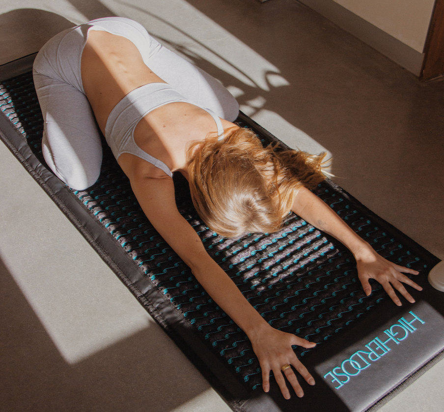 woman doing yoga on the higherdose pemf mat